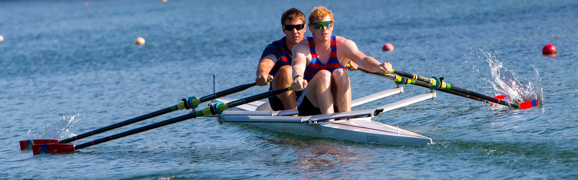 image of two young men rowing on the waterway